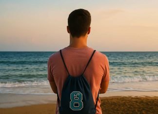 Ways to Boost Your Brand Visibility with Custom Drawstring Bags (UK) Man with drawstring backpack watching sunset on the beach.