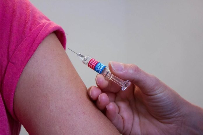 Person receiving an injection in upper arm