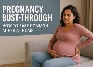 Pregnancy Bust‑Through: How to Ease Common Aches at Home Pregnant woman in a pink long-sleeve shirt and blue jeans sitting on a couch, holding her lower back in discomfort