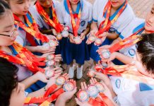 Why Positive Reinforcement Matters in Children’s Sports Group of school children proudly holding medals in a circle