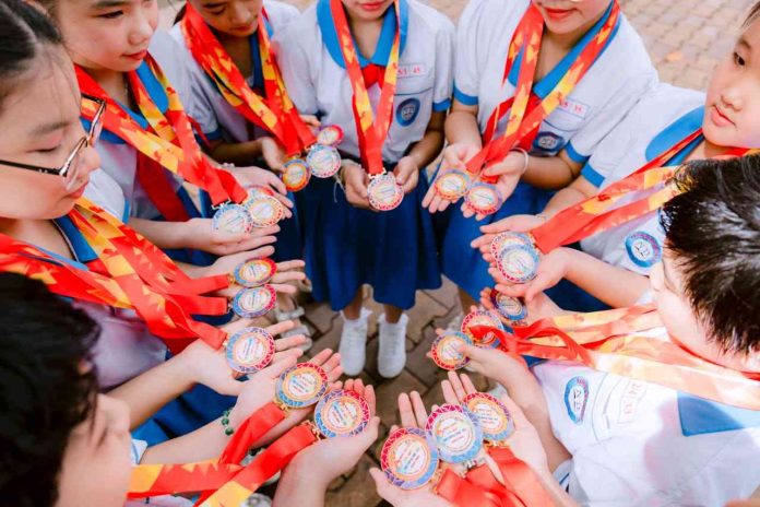 Positive Reinforcement Matters in Children’s Sports (1) Group of school children proudly holding medals in a circle