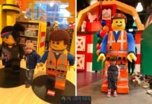 Children posing with LEGO Movie character statues and mascots at LEGO Discovery Center.