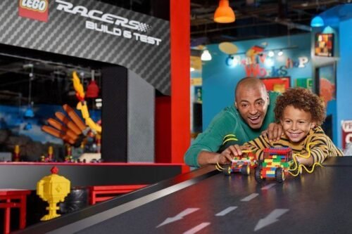 Father and son racing LEGO cars at the LEGO Racers Build & Test area.
